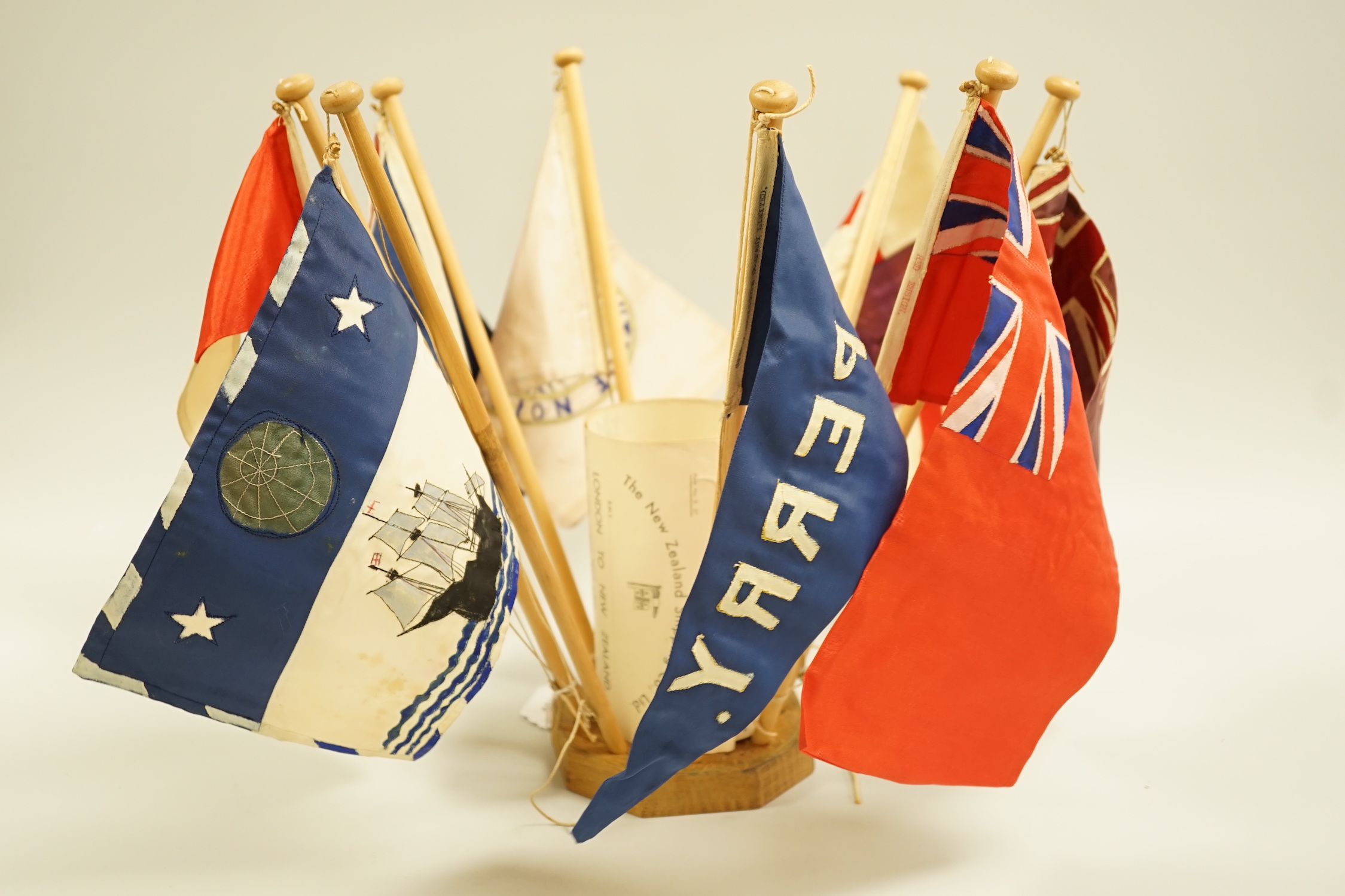 A collection of shipping flags on a stand and a boxed silver oar, engraved: 2nd, Destroyer Flotilla Regatta 1934, 29.5cm long